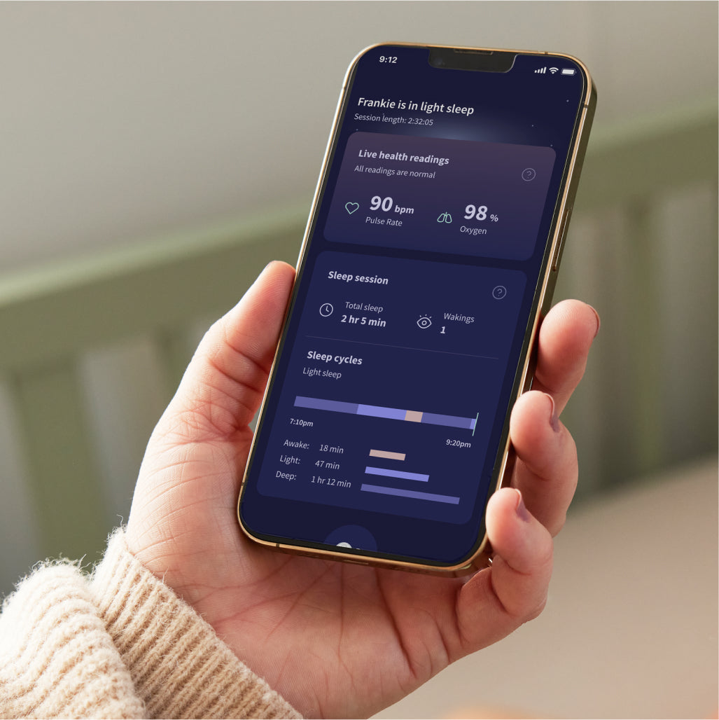 Nahaufnahme einer Person, die ein Smartphone hält, auf dem eine Schlafüberwachungs-App angezeigt wird. Der Bildschirm zeigt detaillierte Schlafdaten, darunter Pulsfrequenz, Sauerstoffgehalt, Gesamtschlafdauer, Anzahl der Aufwachphasen und eine Aufschlüsselung nach Leicht-, REM- und Tiefschlafphasen – fast so, als ob Sie eine Owlet Dream Sock hätten: Medizinisch zertifiziertes Pulsoximeter für Babys von Owletcare.de zur Überwachung Ihrer eigenen Ruhe.