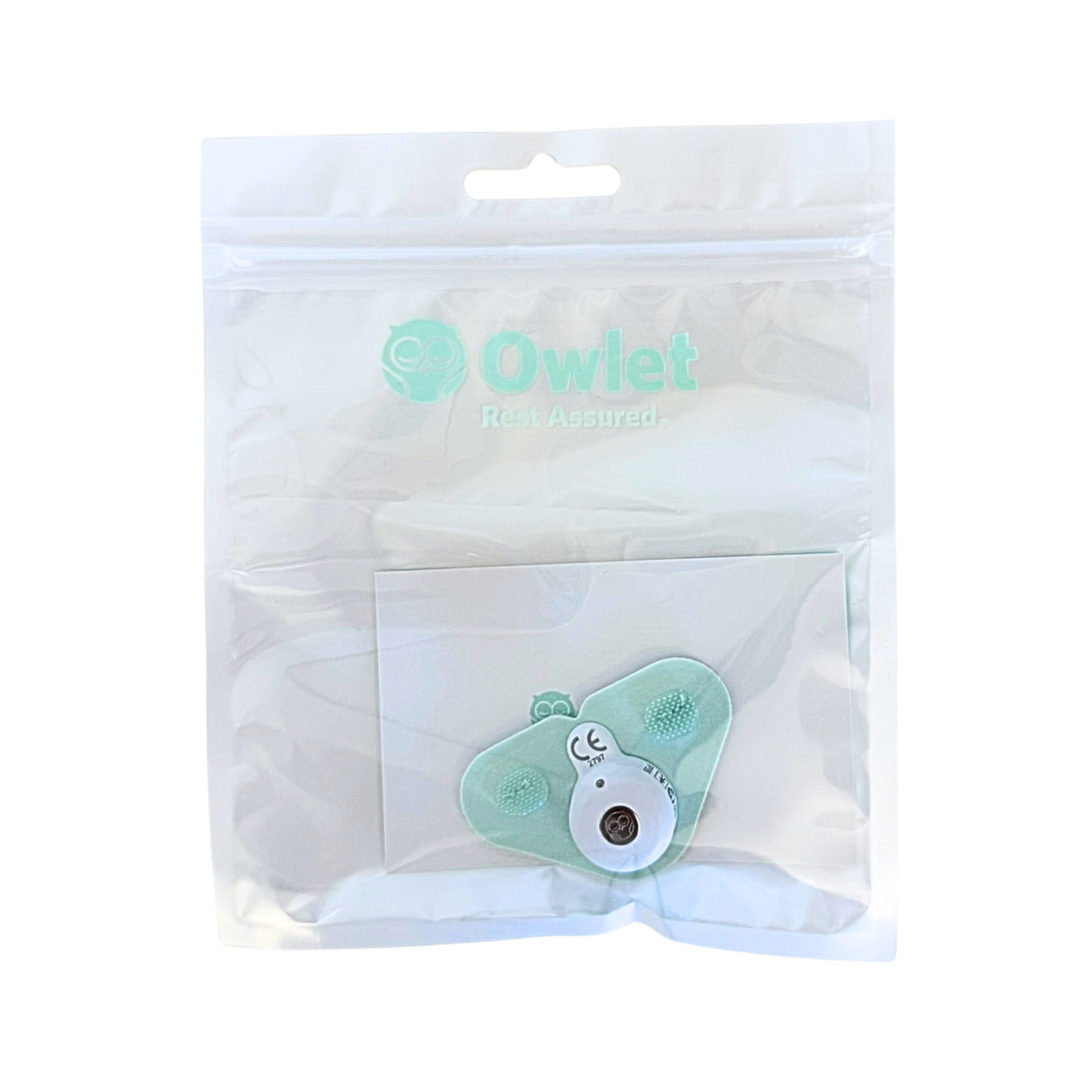 Ein mintgrüner Owlet Dream Sock Sensor von Owlet, versiegelt in einem transparenten Plastikbeutel mit dem Owlet-Logo und dem Aufdruck "Rest Assured" auf der Vorderseite.