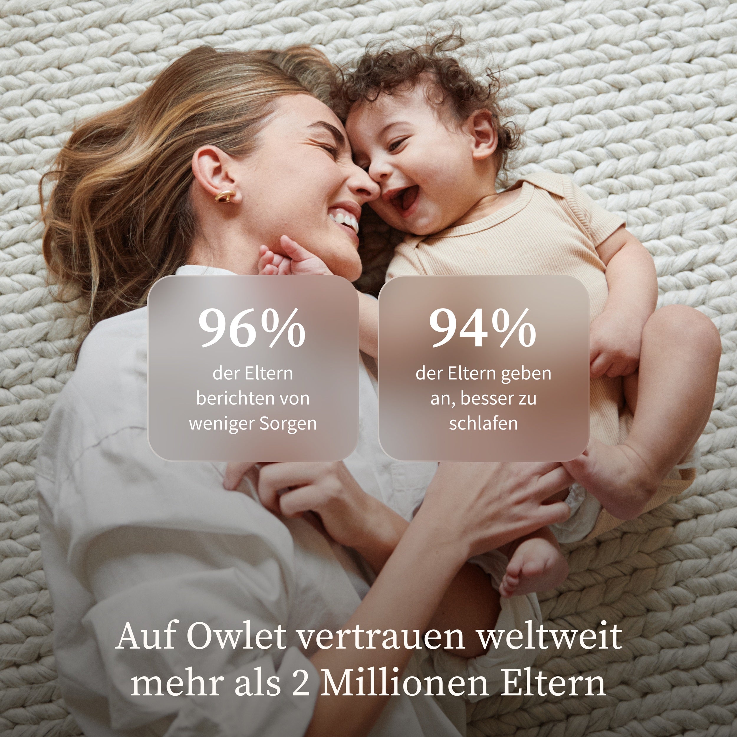 Eine lächelnde Mutter kuschelt mit ihrem glücklichen Baby auf einem cremefarbenen Teppich. Eingeblendet sind deutsche Statistiken: 96% der Eltern fühlen sich weniger besorgt und 94% schlafen besser mit dem Owletcare.de Owlet Dream Sight: Neue 2K HD Babyphone Kamera.