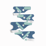 Vier „Owlet Dream Socks“ von Owletcare.de mit Ersatzsocke in Blau und Grün, die für verschiedene Alters- bzw. Gewichtsgruppen konzipiert sind, sind vertikal auf einem weißen Hintergrund angeordnet. Jedes dieser tragbaren medizinischen Geräte verfügt über Klettverschlüsse und runde Öffnungen und ist entsprechend der vorgesehenen Größe des Benutzers beschriftet.