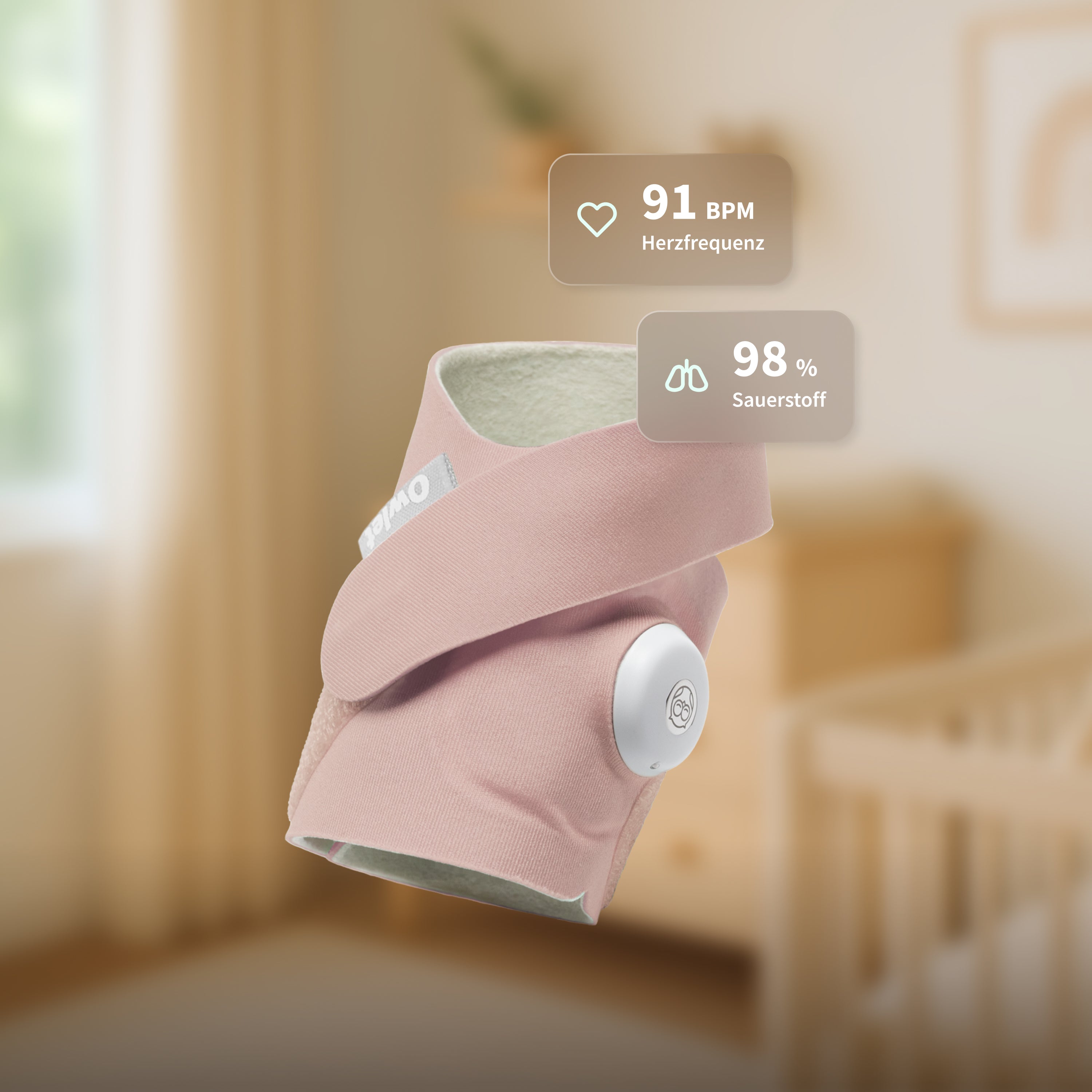 Die „Owlet Dream Sock“ mit Ersatzsocke von Owletcare.de, hier in Rosa abgebildet, zeigt eine Herzfrequenz von 91 Schlägen pro Minute und einen Sauerstoffgehalt von 98 % an. Das tragbare Babyfon schwebt in einem sanft beleuchteten Kinderzimmer, im Hintergrund sind ein Kinderbett und Wandbilder zu sehen.