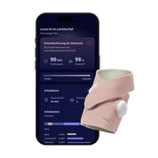 Ein Smartphone, auf dem die Schlafanalyse-App „Owletcare.de“ mit Herzfrequenz- und Sauerstoffdaten angezeigt wird, sowie das rosa „Owlet Dream Sock mit Ersatzsocke“-Armband mit einem Sensor zur Erfassung von Gesundheitsdaten.
