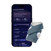 Ein „Owlet Dream Sock“ von Owletcare.de mit Ersatzsocke ist vor einem Smartphone zu sehen, auf dem eine Schlaf-Tracking-App mit Schlafdaten angezeigt wird.