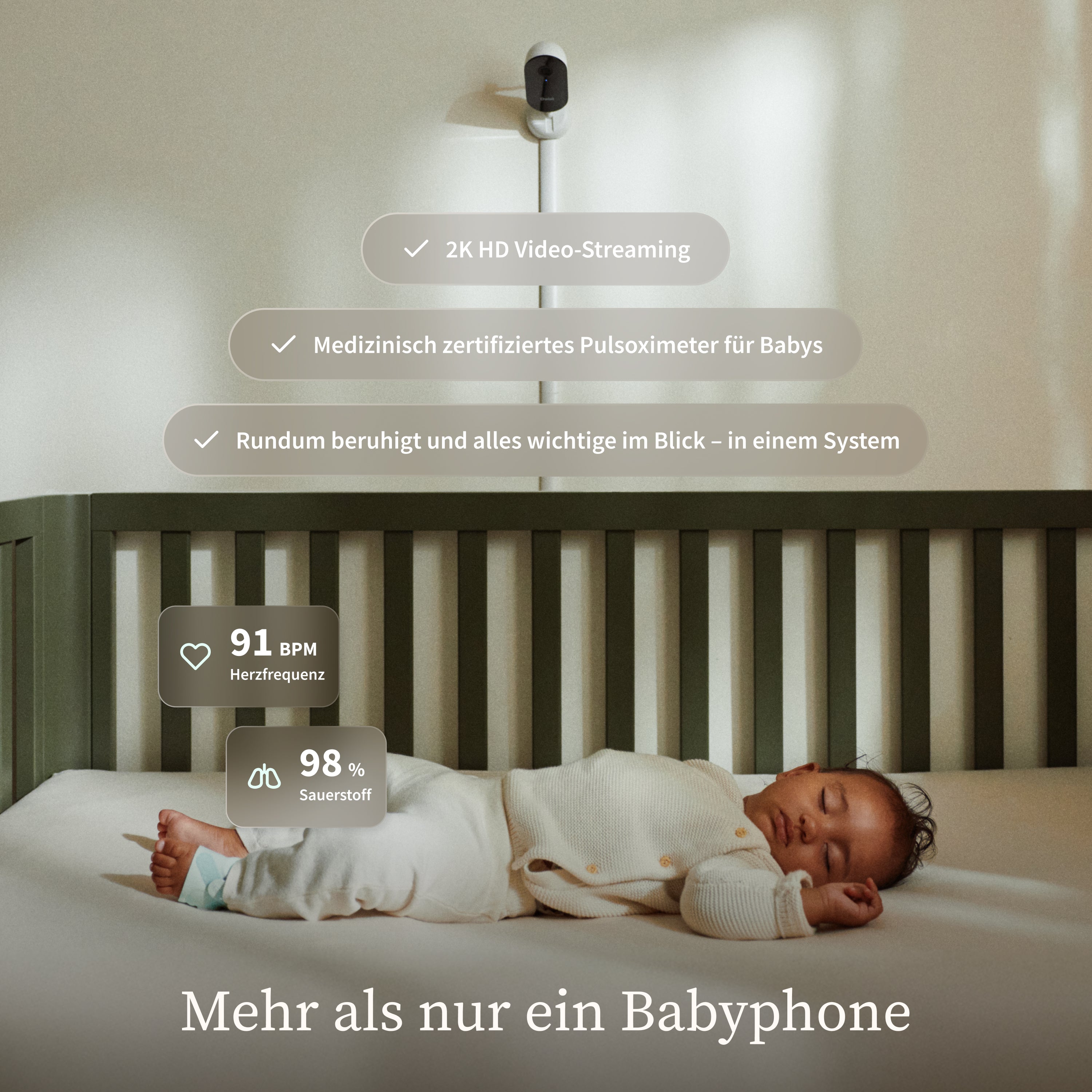 Ein Baby schläft friedlich in einem Kinderbett unter einer an der Wand montierten „Owlet Dream Duo mit Ersatzsocke“-Kamera von Owletcare.de. Auf dem Bildschirm werden Vitalwerte angezeigt, und ein deutscher Text hebt 2K-Video-Streaming, ein zertifiziertes Pulsoximeter und Systemfunktionen hervor. Der Einblendtext lautet: „Mehr als nur ein Babyphone.“.